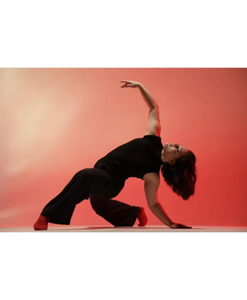 Contemporary dancer arching back in red studio