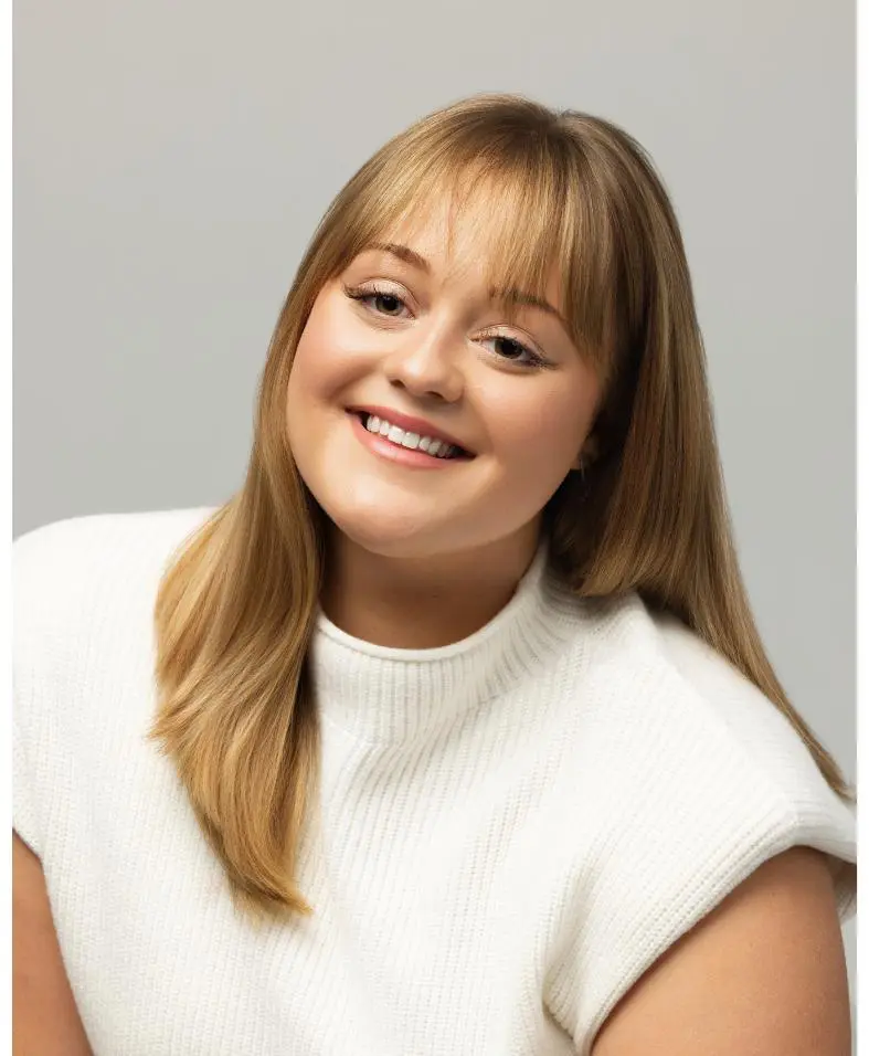 Smiling woman with blonde hair and sweater