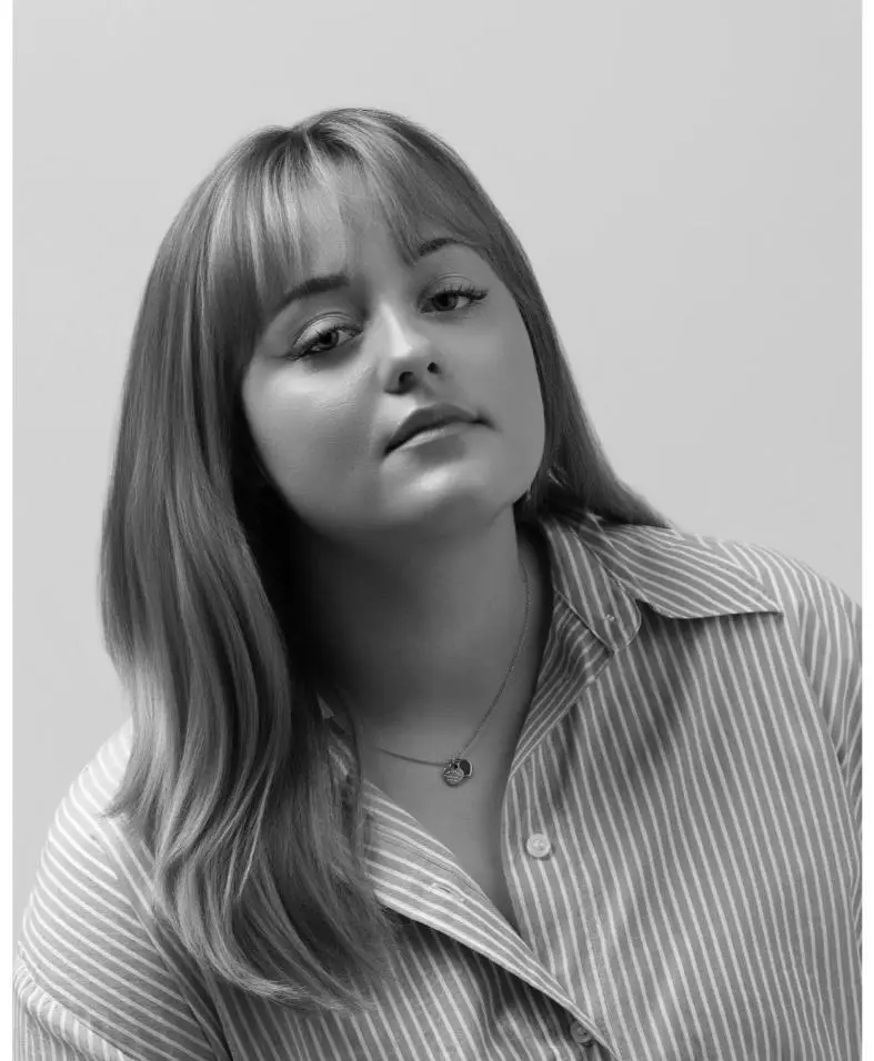 Black-and-white headshot of woman in striped shirt